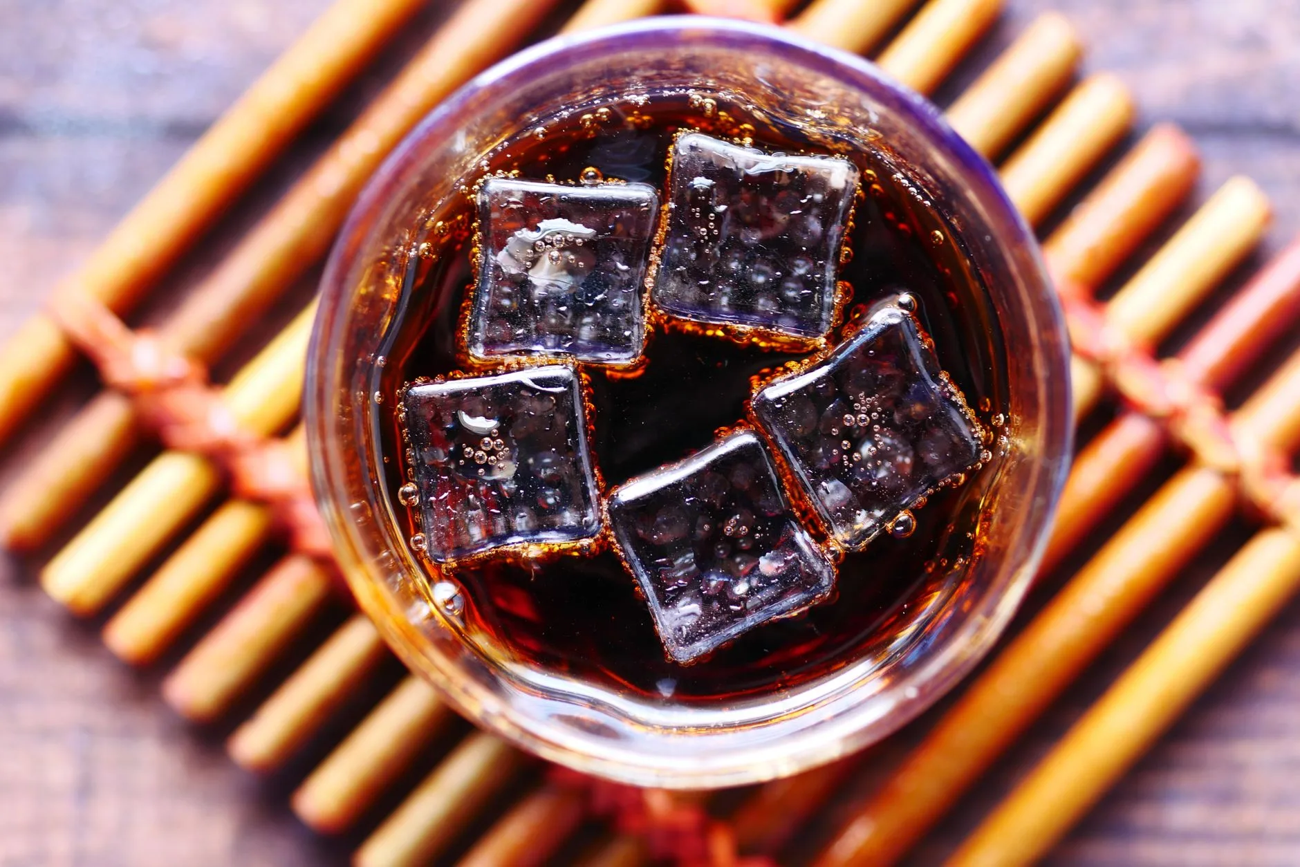 Vaso de ron con cola y hielo visto desde arriba
